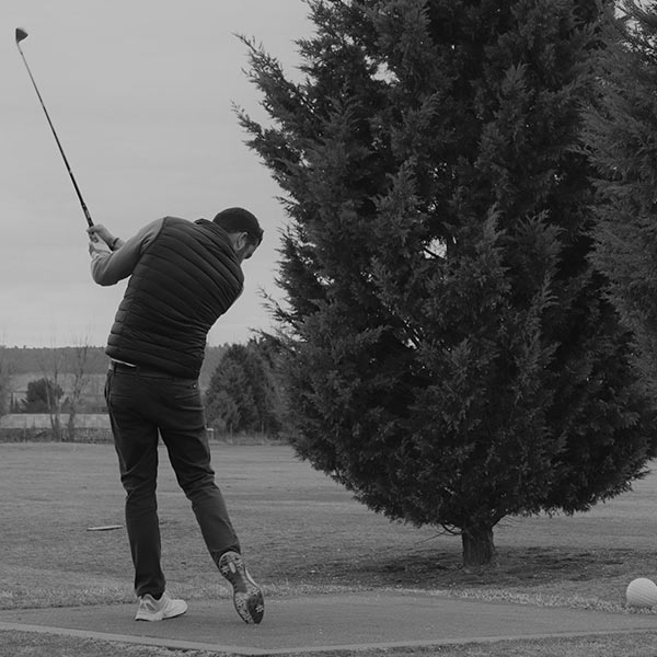 Hombre jugando golf en el campo de Escuela de Golf CyL