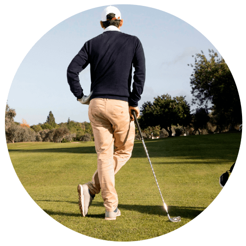 Jugador de golf en el campo apoyándose en el palo