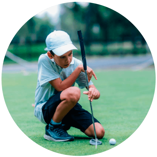 Niño con un palo de golf en un campo